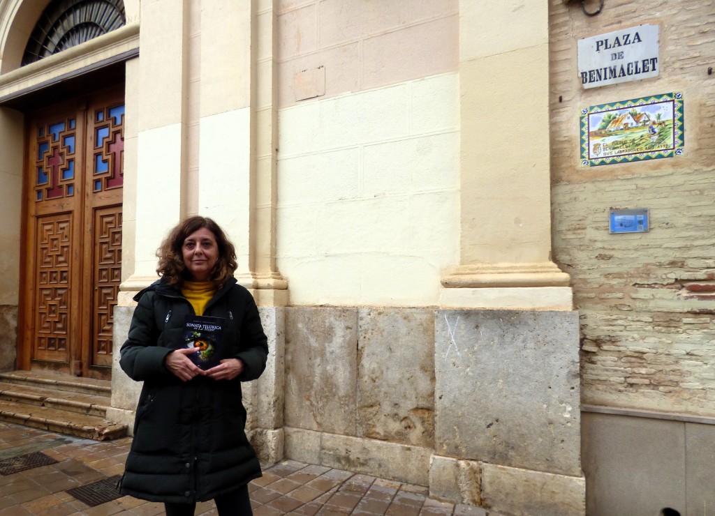 La escritora María Adelantado sostiene  su novela publicada, en la plaza de Benimaclet